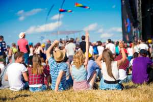 Young people sitting on the ground facing festival stage. Toghill House farm. Bath Festival Finale - Bed and Breakfast near Bath